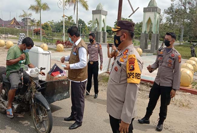 Kapolres Rohul Taufiq Lukman Nurhidayat, Sekda, dan Ketua DPRD bagikan masker gratis ke pedagang di Pasar Modern Pasir Pangaraian.