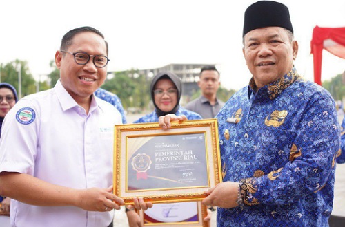 Plt Gubernur Riau, SF Hariyanto menerima penghargaan UHC dari BPJS Kesehatan saat peringatan HKN ke-61.(foto: sri/halloriau.com)