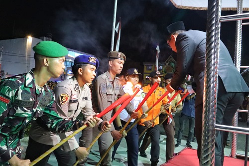 Wakil Bupati Rohil, Jhony Charles menyalakan obor di Malam Taptu.(foto: afrizal/halloriau.com)