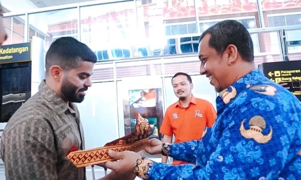 Kadispar Riau, Roni Rakhmat (kanan) menghadiahkan Tanjak ke Youtuber Joe Hattab (foto/ist)