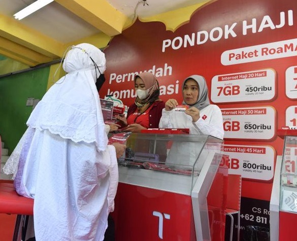 Vice President Consumer Sales Jawa Bali Riny Novitriyanti (kanan) menawarkan kartu Telkomsel kepada jamaah calon haji di posko haji Telkomsel, Asrama Haji Sukolilo, Surabaya, Jawa Timur, Selasa (31/5/2022). 