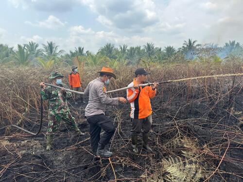 Personel Polres Inhil bersama tim gabungan saat melakukan olah TKP di lokasi kebakaran lahan gambut di Desa Sungai Intan. (Foto: Ayendra)
