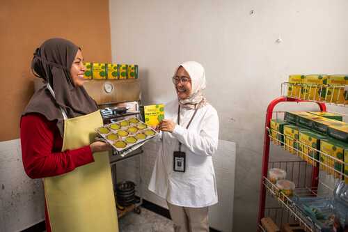 Sri Hidayani yang akrab disapa Mak Zai. Dengan cekatan, tangannya menuangkan adonan bolu berwarna hijau cerah ke dalam loyang, melanjutkan warisan keluarga yang telah lama terjaga. (Foto: Istimewa)