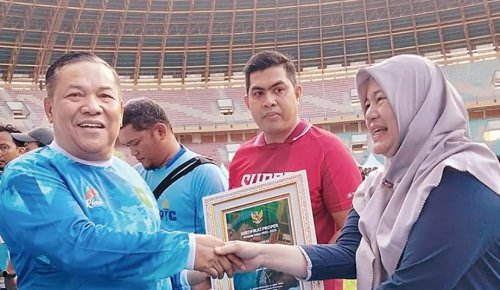 Plt Gubri SF Hariyanto menyerahkan penghargaan ke perwakilan PTPN IV Regional III di Stadion Utama Riau, Pekanbaru, belum lama ini (foto/ist)