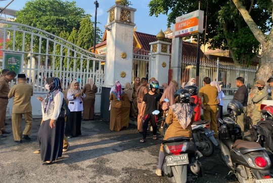 Sejumlah ASN Pemprov Riau berdiri di luar pagar karena terlambat ikut apel perdana (foto/Yuni)