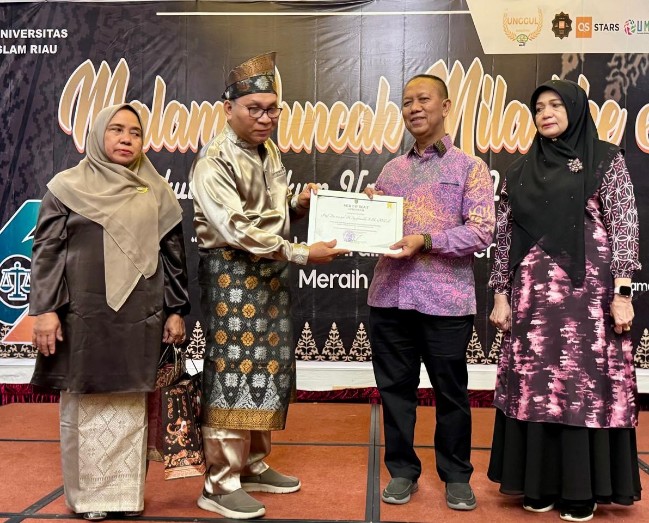 Penyerahan piagam dan cenderamata ucapan purna tugas dari Dekan Musa kepada mantan Rektor UIR Syafrinaldi dan istri.