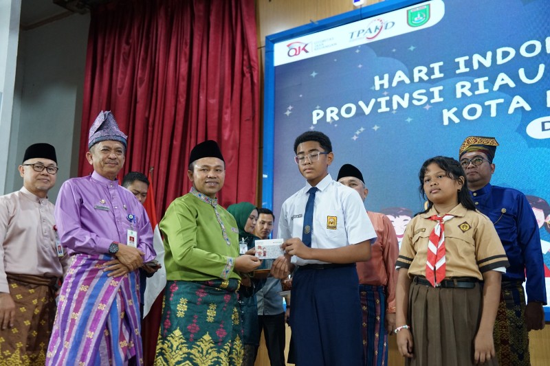 Gubri Wahid serahkan buku rekening ke pelajar dalam acara Hari Indonesia Menabung 2025 di Dumai (foto/bambang)