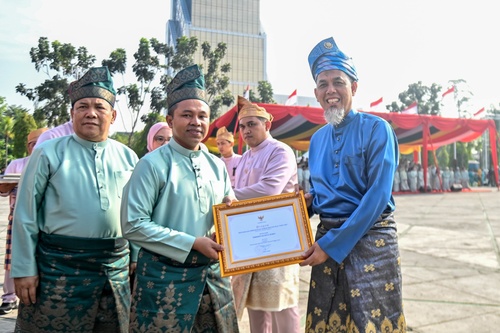 Walikota Dumai, H. Paisal, menerima Piagam Penghargaan Pembangunan Daerah Provinsi Riau Tahun 2025 dari Gubernur Riau, Abdul Wahid, usai Apel Peringatan Hari Jadi ke-68 Provinsi Riau di Halaman Kantor Gubernur Riau, Pekanbaru, Sabtu (9/8/2025). (Foto: Bambang)