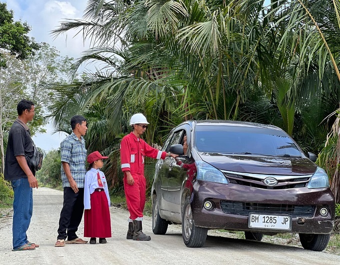 Sejumlah warga Merbau melintasi jalan akses Sagu-sagu di Dusun Sungai Kurau, Desa Lukit, Kabupaten Kepulauan Meranti. PT Imbang Tata Alam (PT ITA) merampungkan perbaikan jalan akses tersebut untuk mendukung kelancaran arus mudik menjelang Idul Fitri.