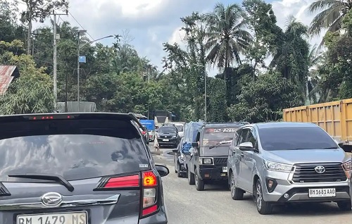 Antrean kendaraan akibat macet di Jalan Lintas Sumbar-Riau wilayah Manggilang, Lima Puluh Kota, Sumbar.(foto: tribunpekanbaru.com)