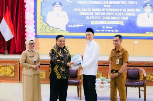 Plt Gubri, SF Hariyanto menyerahkan data penunggak pajak kendaraan ke Walikota Dumai, Paisal (foto/ist)