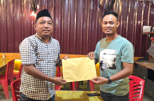 Salah satu calon Ketua PWI Rohil, Zulfadhli menyerahkan Berkas kepada ketua Panpel Konferkab, Sutrisno (foto/afrizal)