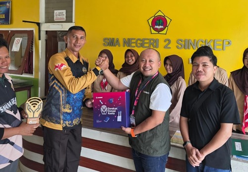Territory Sales XLSMART area Batam, Dedy Prasetyawan (jaket hijau) saat menyerahkan donasi kuota internet dan perangkat pendukung kepada perwakilan lembaga yang mendapat program ini di Pulau Lingga, Kepulauan Riau. Kamis (11/9). (Foto: Istimewa)