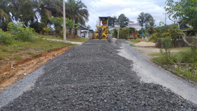 Sebuah alat berat sedang bekerja melakukan pengaspalan jalan di Dusun Kopau, Kelurahan Kerumutan, Kecamatan Kerumutan, Kabupaten Pelalawan (foto/ist)