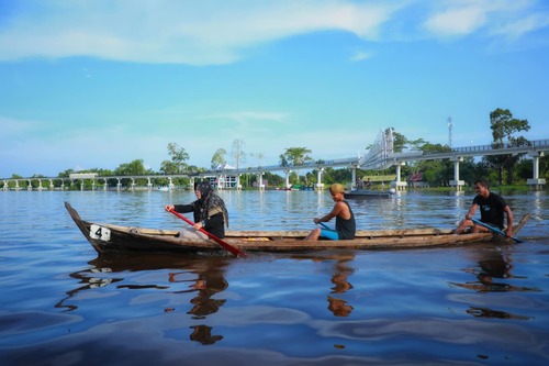 Bupati Siak, Afni mendayung sampan menyeberangi Sungai Siak. (Foto: Diana Sari)