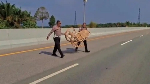 Petugas Sat PJR saat mengevakuasi kursi goyang yang jatuh di badan jalan ruas Tol Pekanbaru-Dumai.(foto: tribunpekanbaru.com)