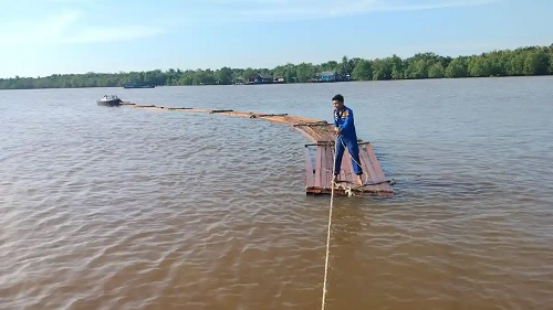 Proses evakuasi rakit kayu diduga hasil ilegal logging di Meranti.(foto: tribunpekanbaru.com)