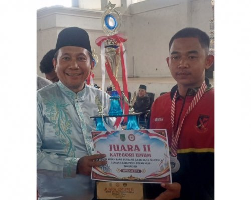 Kepala Bakesbangpol Rohil, Cicik Mawardi Athar menyerahkan hadiah kepada salah satu pemenang LKBB Duta Pancasila (foto/afrizal)