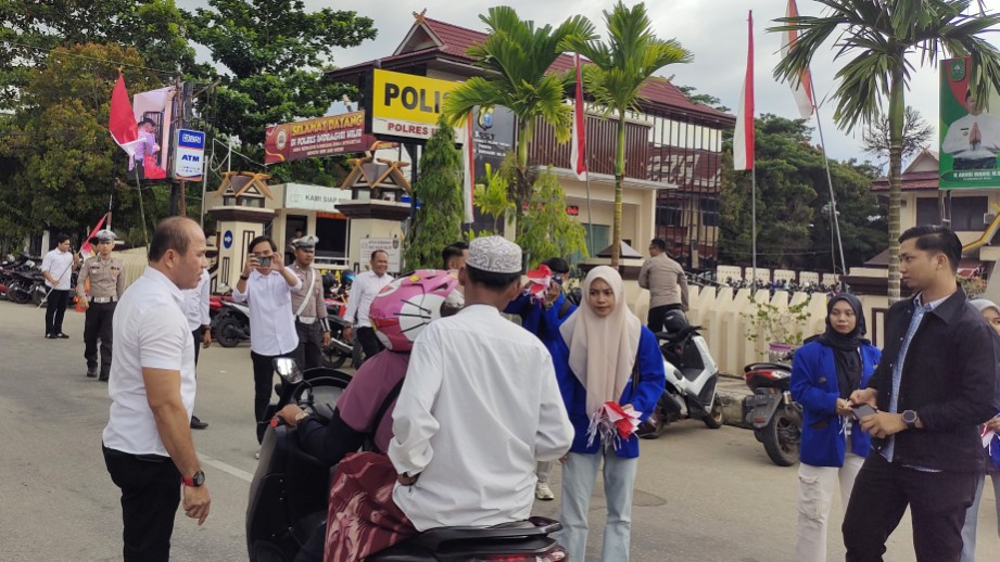 Sat Intelkam Polres Inhil bersama mahasiswa membagikan bendera merah putih untuk para pengendara (foto/yendra)