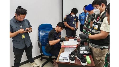 Petugas gabungan saat mengecek isi paket sepatu yang ternyata di dalamnya ditemukan narkotika jenis sabu dan ekstasi.  (Foto: Tribun Pekanbaru)