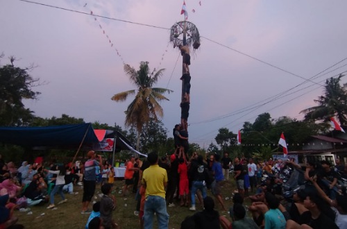 Kegiatan panjat pinang semarak HUT ke-80 RI di Tangkerang Labuai.(foto: fajar/halloriau.com)