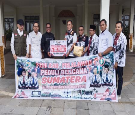 Bupati Pelalawan H Zukri, MM menerima hasil penggalangan dana dari PGRI Pelalawan (foto/Andy)