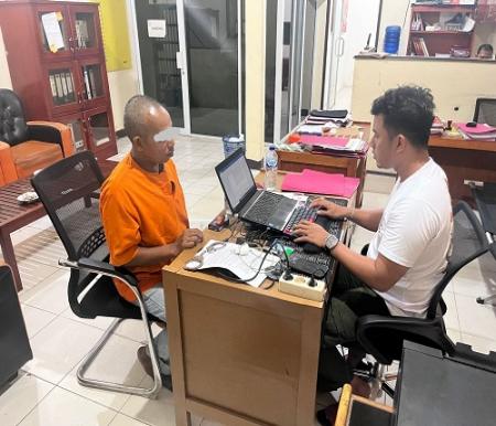 Tersangka A saat diamankan di Mapolsek Bandar Sei Kijang.(foto: andi/halloriau.com)