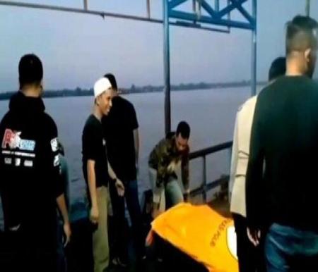 Petugas kepolisian saat mengevakuasi kedua korban tewas tersambar petir di perairan Sungai Indragiri, Kecamatan Tembilahan, Kabupaten Indragiri Hilir, Riau. (Foto: Kompas)