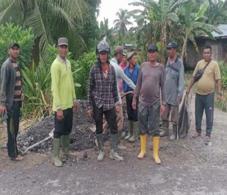 Kegiatan gotong royong warga Parit Aman perbaiki jalan rusak.(foto: afrizal/halloriau.com)