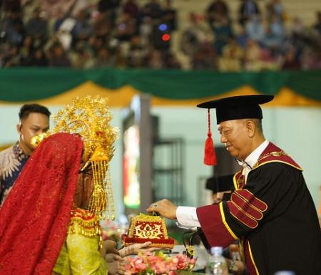 Rektor Universitas Islam Riau, Prof. Dr. Rer. Pol. H. Syafrinaldi, S.H., MCL., menerima tapur sirih sebagai simbol penghormatan dalam prosesi Wisuda Periode II Tahun 2025 di Gedung Gelora UIR, Rabu (18/6/2025).