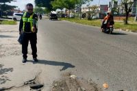 Polantas menunjukkan lokasi kecelakaan maut di Jalan Soekarno Hatta Pekanbaru.(foto: tribunpekanbaru.com)