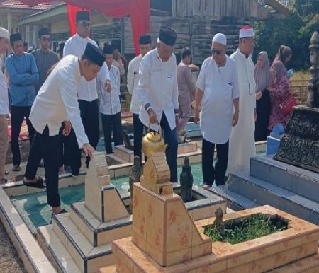 Bupati Pelalawan, Zukri saat ziarah kubur di Desa Kuala Terusan.(foto: andi/halloriau.com)