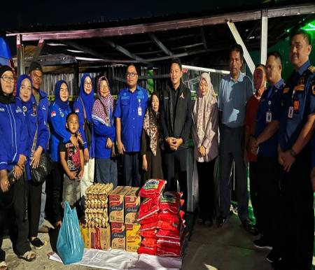 Ketua Fraksi Demokrat DPRD Kota Pekanbaru, Achmad Faisal Reza serahkan bantuan untuk korban kebakaran (foto/Mimi)