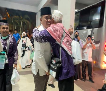 Bupati Zukri berpelukan dengan jemaah haji Pelalawan yang tiba di Batam (foto/Andy)