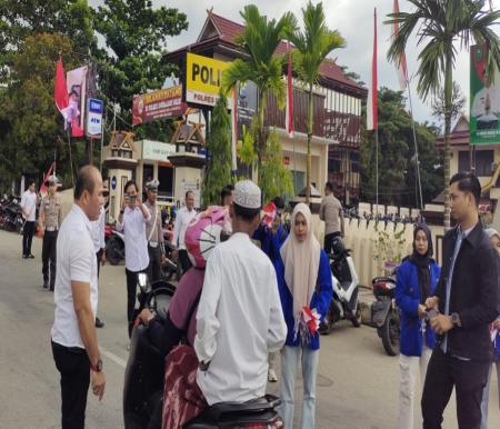 Sat Intelkam Polres Inhil bersama mahasiswa membagikan bendera merah putih untuk para pengendara (foto/yendra)